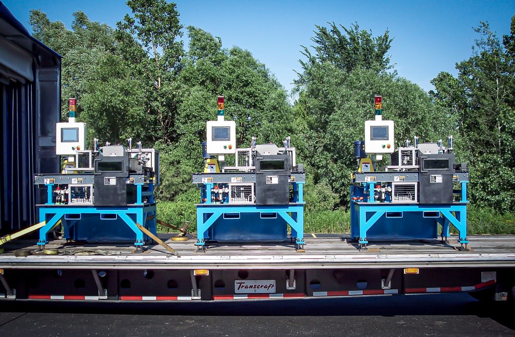 Three custom production machines secured for delivery.
