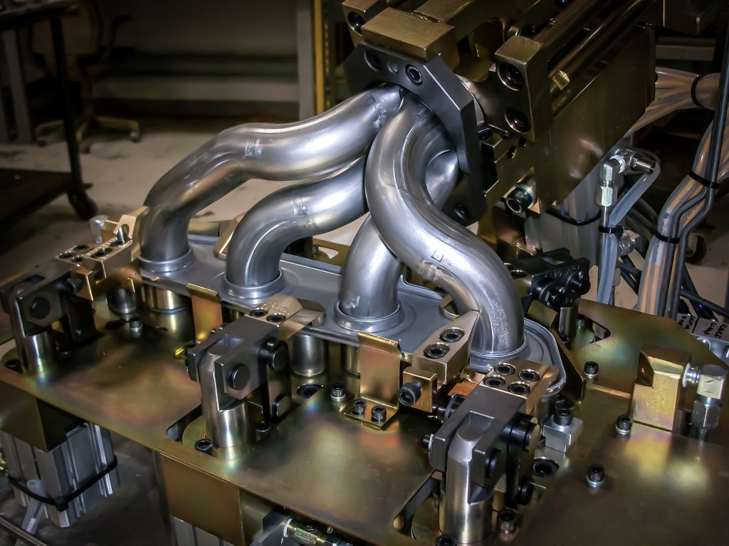 Exhaust manifold secured in a custom weld fixture.