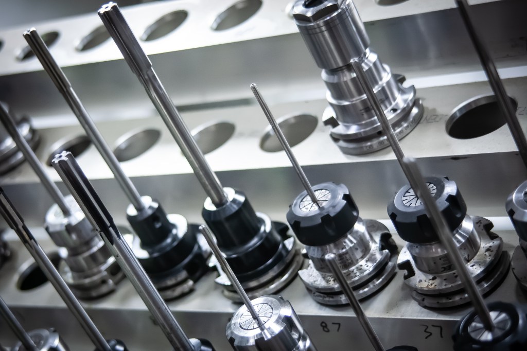 Precision milling cutters and tool holders arranged in machine storage.