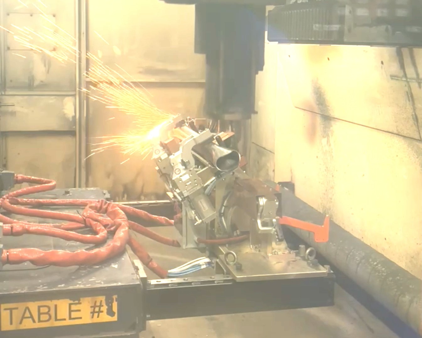 Laser cutting fixture operating inside an enclosed laser cell.