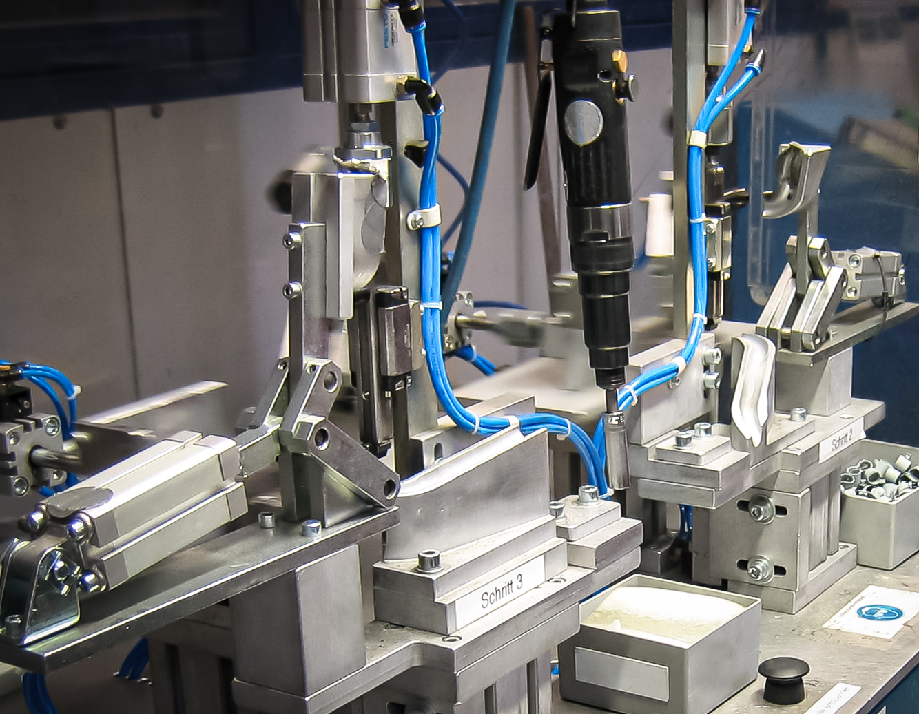 Pneumatic workholding fixture with precision locators and blue air lines.