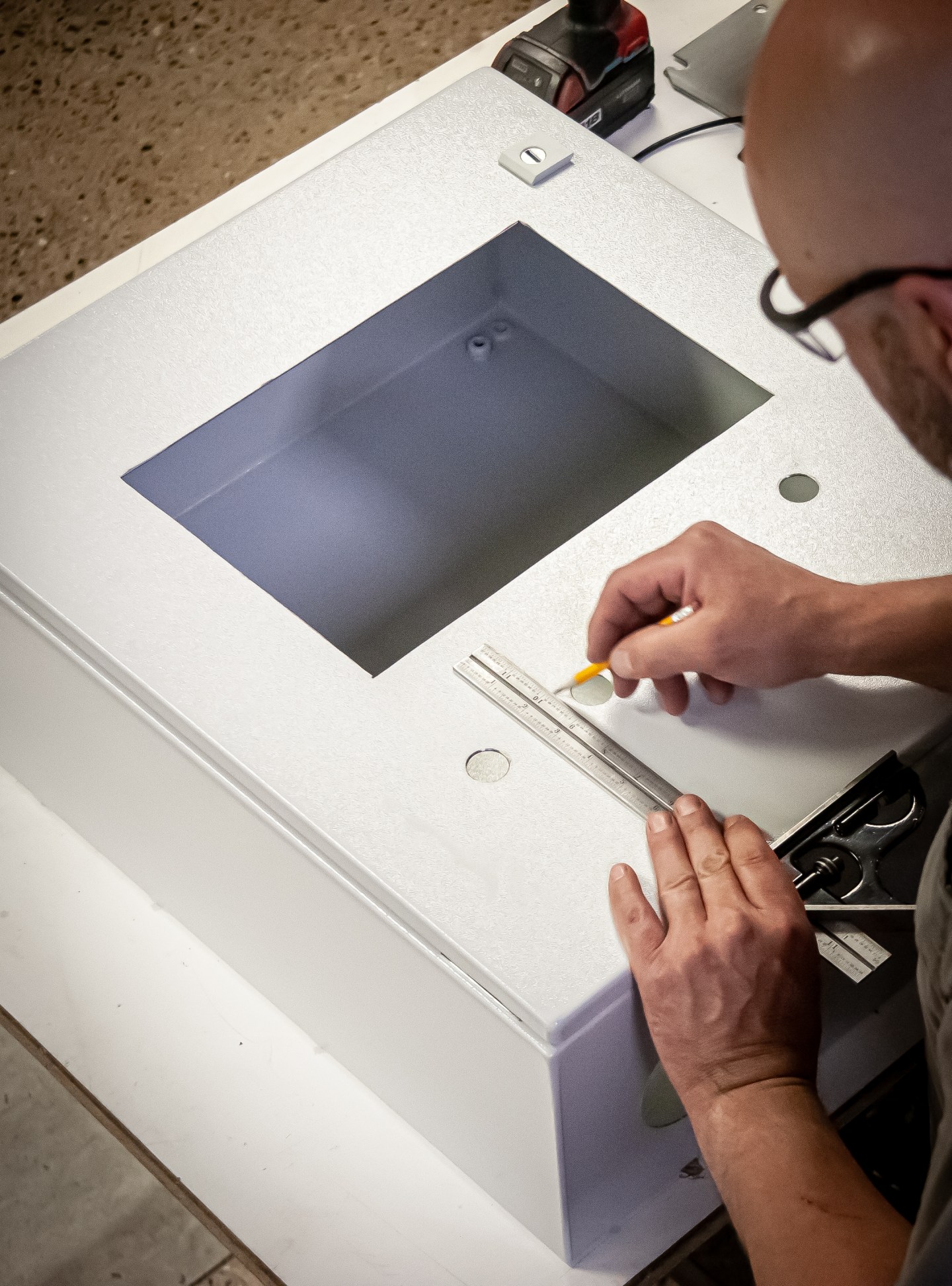Technician preparing a control-panel enclosure.