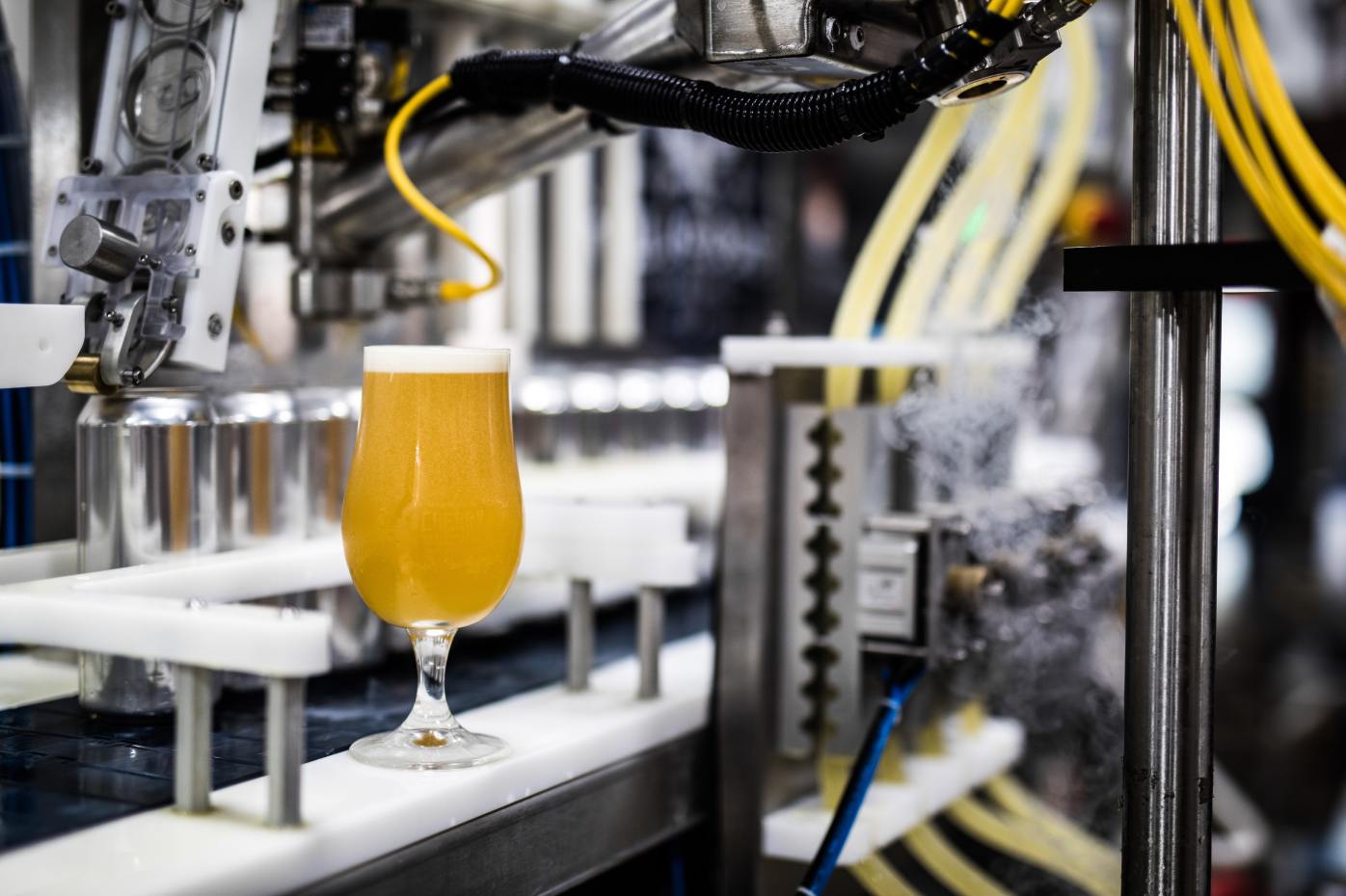 Automated beverage filling line dispensing a drink into a glass
