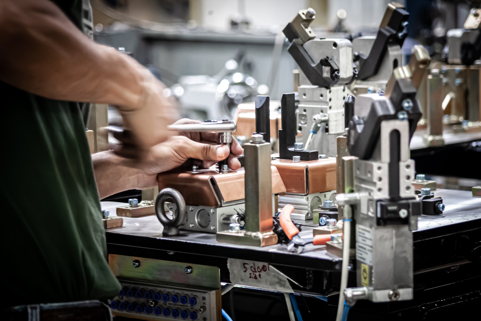 Technician adjusting clamps on a custom manufacturing fixture